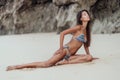 Young sensual woman in color bikini rests on vacation at sandy beach Royalty Free Stock Photo