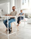 Young serious african american businessman using a desktop computer in an office at work. Focused male businessperson