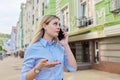 Young serious business woman talking on mobile phone, city street background Royalty Free Stock Photo