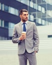 Young serious businessman with paper cup outdoors Royalty Free Stock Photo