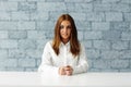 Young serious businesswoman sitting at the table Royalty Free Stock Photo