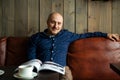 Young serious fashionable man sitting alone in loft-styled cafe Royalty Free Stock Photo