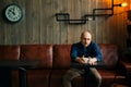 Young serious fashionable man sitting alone in loft-styled cafe Royalty Free Stock Photo