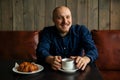 Young serious fashionable man sitting alone in loft-styled cafe Royalty Free Stock Photo