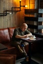 Young serious fashionable man sitting alone in loft-styled cafe Royalty Free Stock Photo