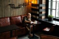 Young serious fashionable man sitting alone in loft-styled cafe Royalty Free Stock Photo