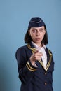 Young serious flight attendant pointing at camera with finger