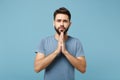 Young serious handsome man in casual clothes posing isolated on blue wall background, studio portrait. People sincere Royalty Free Stock Photo