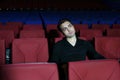 Young serious man in black watches movie