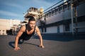 Young serious man doing pushups outdoor on industrial background Royalty Free Stock Photo