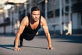 Young serious man doing pushups outdoor on industrial background Royalty Free Stock Photo