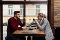 Young serious man having conversation with woman girlfriend sit at cafe table, focused male friend talking to female colleague Royalty Free Stock Photo