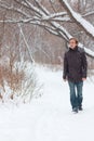 Young serious man in jeans walk in forest at winter Royalty Free Stock Photo