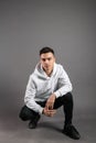 Young serious man posing in studio. Gray background