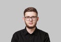 Young serious man with stylish neat beard, wearing a black shirt and in glasses Royalty Free Stock Photo
