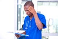 Young serious male doctor checking notes on clipboard Royalty Free Stock Photo