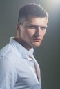 Young serious man in white shirt over gray background. Studio portrait Royalty Free Stock Photo