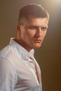 Young serious man in white shirt over gray background. Studio portrait Royalty Free Stock Photo