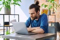 Young serious man working, studying using laptop sitting in coworking cafe Royalty Free Stock Photo