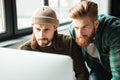 Young serious men colleagues in office using computer Royalty Free Stock Photo