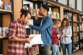 Young serious men students standing in library reading books Royalty Free Stock Photo