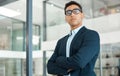 Young serious mixed race businessman standing with his arms crossed alone at work. One confident hispanic male manager Royalty Free Stock Photo