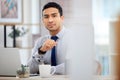 Young serious mixed race businessman working on a laptop alone in an office at work. One focused hispanic businessperson Royalty Free Stock Photo