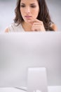 Young, serious and thinking businesswoman on a computer working on solving a business problem. Professional caucasian Royalty Free Stock Photo