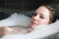 Young serious woman enjoys the bath-foam Royalty Free Stock Photo