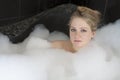 Young serious woman enjoys the bath-foam Royalty Free Stock Photo