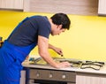 Young service contractor assembling kitchen furniture