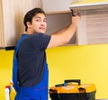 Young service contractor assembling kitchen furniture