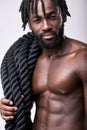 young sexy active black man going to train with battle ropes, keeping fit, isolated