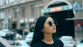 Young asian brunette in sunglasse walks around the street