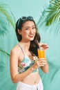 Young sexy asian woman in mini denim shorts drinking tasty juice on summer time Royalty Free Stock Photo