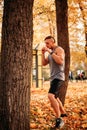 Young athlete practicing blows on a tree in the park