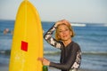 Young beautiful and happy surfer girl holding yellow surf board smiling cheerful drinking beer bottle enjoying summer holiday Royalty Free Stock Photo