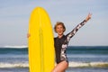 Young beautiful and happy surfer girl holding yellow surf board smiling cheerful enjoying summer holidays in tropical beach w Royalty Free Stock Photo