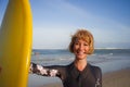 Young beautiful and happy surfer girl holding yellow surf board smiling cheerful enjoying summer holidays in tropical beach w Royalty Free Stock Photo