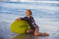 Young beautiful and happy surfer woman sitting on beach sand holding yellow surf board smiling cheerful enjoying summer holid Royalty Free Stock Photo