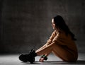 Young blonde fashion woman sitting on floor in brown knitted blouse Royalty Free Stock Photo