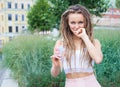 Young blonde girl with dreads eating multicolored ice cream in waffle cones in summer evening, joyful and cheerful. Europea Royalty Free Stock Photo