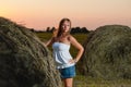 Young blonde posing near a haystack