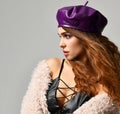 Young brunette woman in purple beret hat looking at the corner Royalty Free Stock Photo