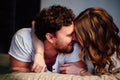 Young couple in love lying in bed in hotel, embracing on white sheets, close up Royalty Free Stock Photo