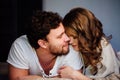 Young couple in love lying in bed in hotel, embracing on white sheets, close up Royalty Free Stock Photo