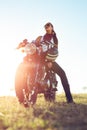 Young girl sitting on vintage custom motorcycle and drinking juice . Outdoor lifestyle portrait Royalty Free Stock Photo