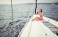 A young sexy girl who is taking a selfie while sitting on the towel and enjoying a sunbath on a yacht on the sea. Summer, sea, Royalty Free Stock Photo