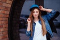 Young sexy glamour woman wearing jeans jacket and baseball cap. Lifestyle city portrait in swag style Royalty Free Stock Photo