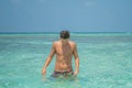 Young sexy handsome male model guy enjoying sun bathing near ocean at tropical sandy beach at island luxury resort